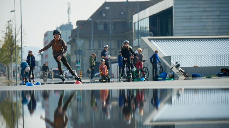 Kinder üben Slaloms mit Inlineskates auf dem Esplanadeplatz