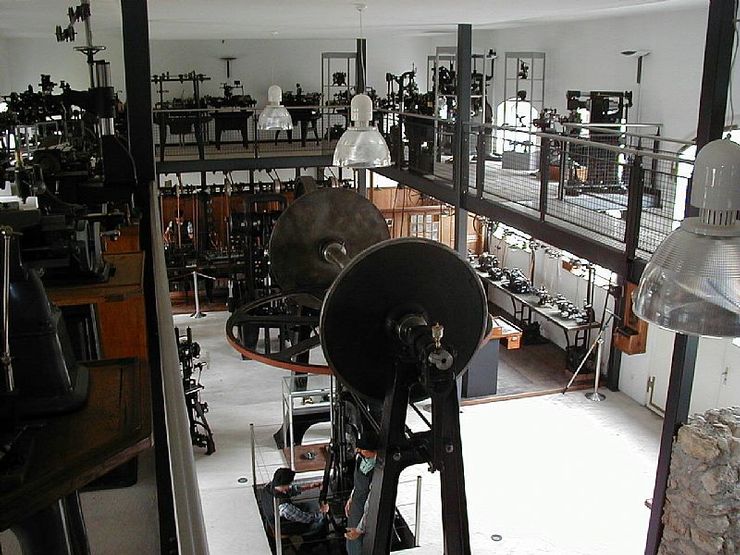Une grande salle haute, de plusieurs étages, dans laquelle se trouvent de nombreuses machines métalliques. 