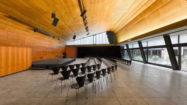 Platz 1: Farelhaus am Oberen Quai 12. Das Foto zeigt den grossen Saal mit einer Event-Bestuhlung und einer Bühne. Die Wände sind aus Holz und es hat grosse Fenster.
