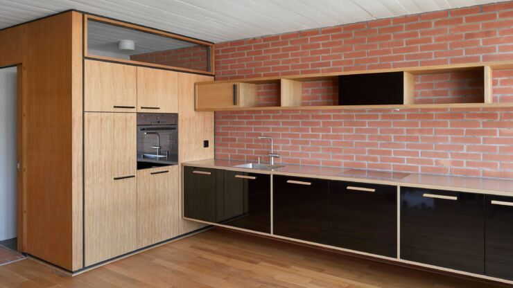 Platz 1: Farelhaus am Oberen Quai 12. Ansicht einer Wohnung mit einer Küche aus Holz, Parkettboden und roter Backsteinmauer.