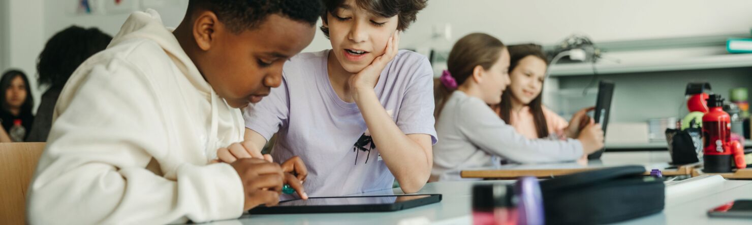 Zwei Kinder arbeiten gemeinsam mit dem iPad