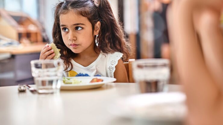 Ein Mädchen ist in einer Tagesschule am Essen.