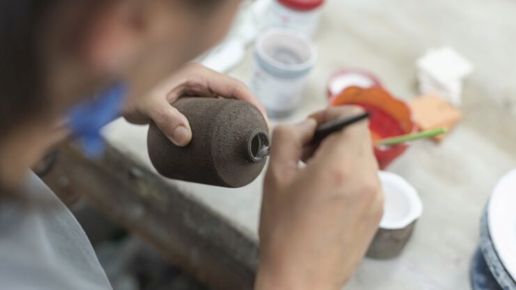 Eine Teilnehmerin des Keramikateliers arbeitet an einer Vase.