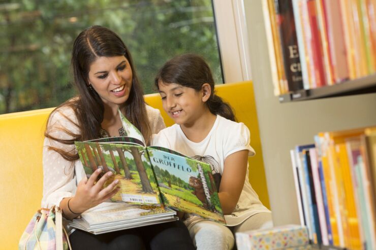 Eine Freiwillige des Projekts «Mit mir» liest einem Kind aus einem Buch vor.