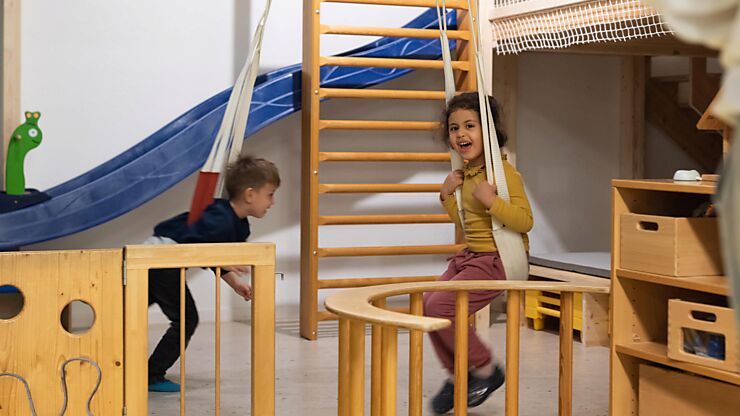 Zwei Kinder spielen vergnügt in der Bewegungsecke im Innenbereich der Kita.