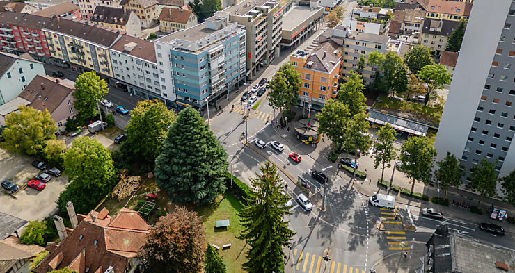 Blick von oben auf den Kreuzplatz mit der Kreuzung und links ein Park und rechts ein Hochhaus. 