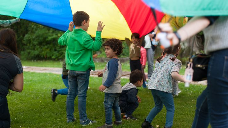 Enfants jouant sur la pelouse du FamiPlus, le lieu de rencontre pour familles.