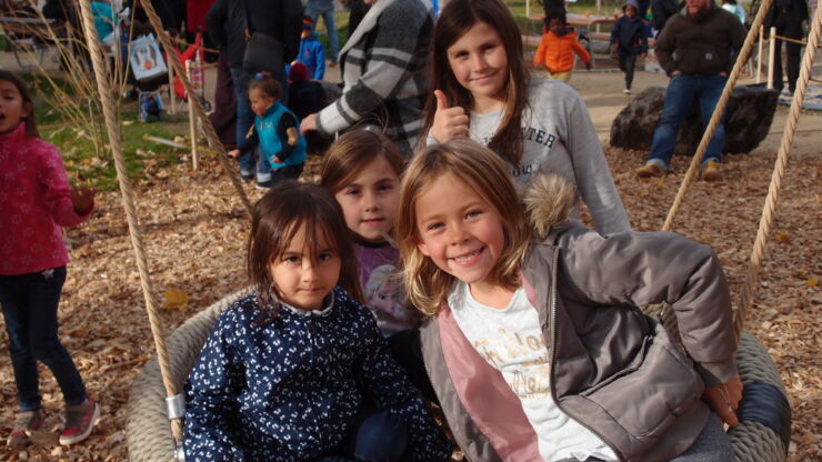 Einweihungsfest Kinderspielplatz Bergfeld: Eine Gruppe von Mädchen auf einem Schaukelring aus Schnur
